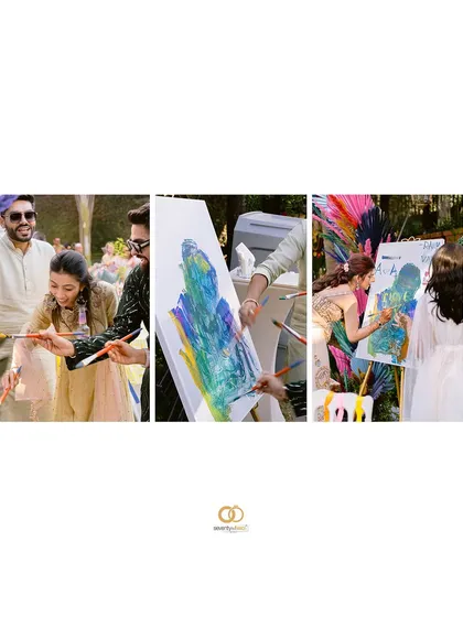 A fun and interactive moment where guests and the couple are painting on a canvas during the Mehendi celebrations.