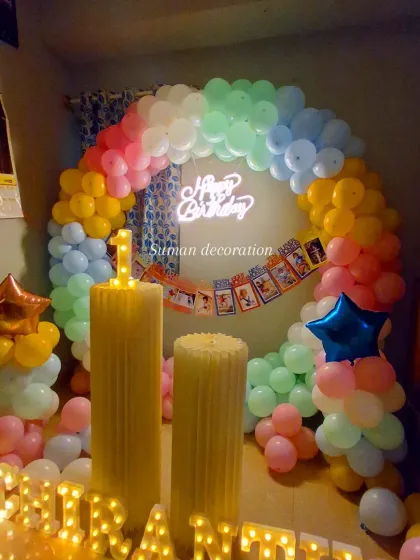 A view of the pastel rainbow setup in lower light, showing how the neon sign and marquee letters create a warm and celebratory glow.