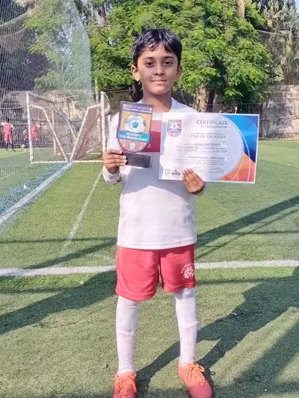 Our player proudly displaying his certificate and award on the turf, a result of dedicated training.