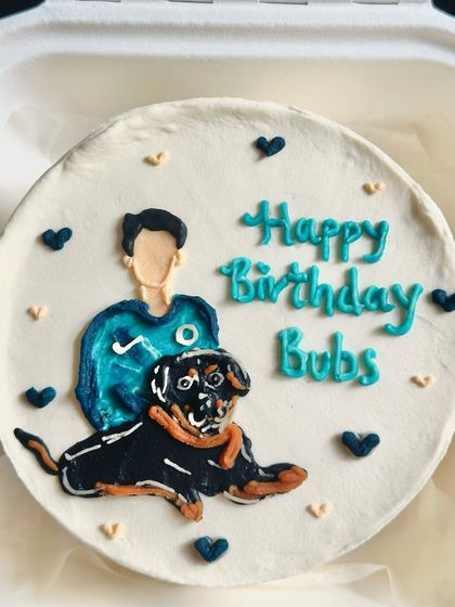 A close-up of the hand-painted pet portrait cake. You can see the detailed layers of buttercream used to create the dog's fur and expression.