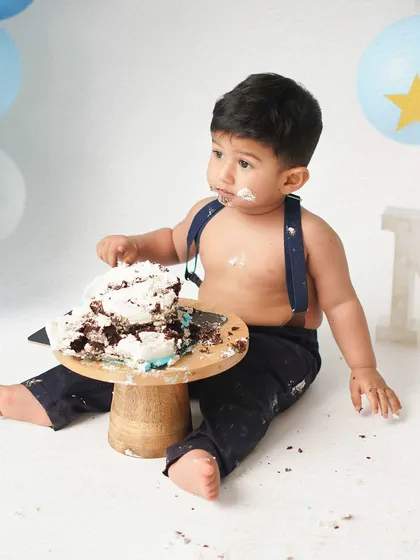 Another shot of the cake investigation. The 'Twinkle Twinkle Little Star' theme with blue and gold balloons is a classic choice for a baby boy's first birthday.