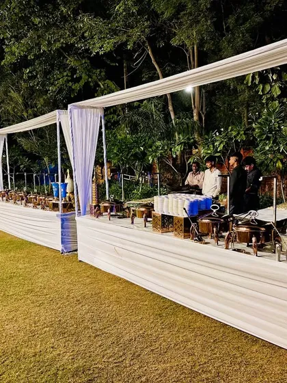 A classic white canopy setup for an outdoor event, providing an elegant and clean look for a large buffet line.