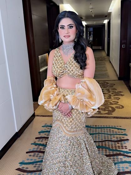 A stunning client ready for a party. The focus is on a glamorous eye and glowing skin, paired with a beautiful gold outfit.