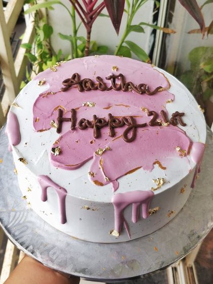 Pretty in pink. This dark chocolate mousse cake is decorated with a pink drip effect and flecks of edible gold leaf for a modern and stylish birthday cake.