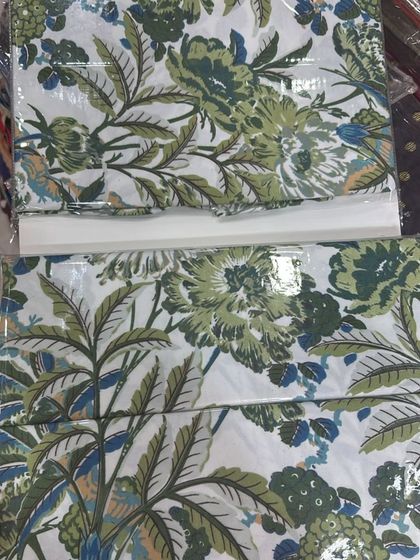 A fresh, botanical print with lush green leaves and flowers on a crisp white background. This Indian cotton bedsheet brings a touch of nature indoors and feels wonderfully cool.