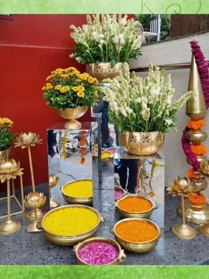 This decor corner for a South Indian wedding features traditional elements like brass lamps, lotus-shaped candle holders, and bowls of fresh flower petals, creating an auspicious and beautiful display.