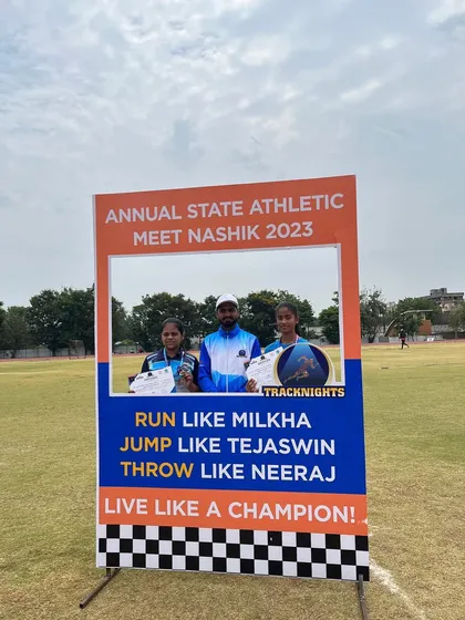 Athletes pose at the photo booth, which reads "Run like Milkha, Jump like Tejaswin, Throw like Neeraj, Live like a Champion!"