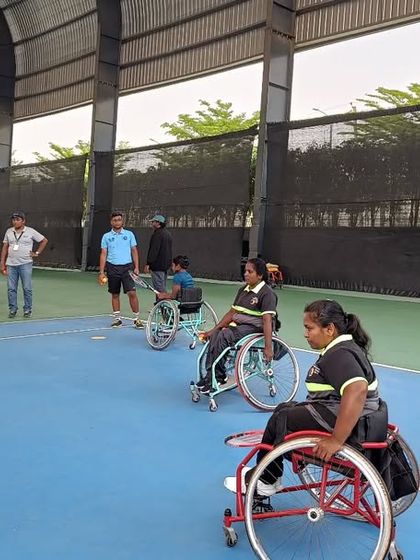 A dynamic action shot of a wheelchair tennis workshop in progress. Players are lined up for a drill, showcasing the structured and engaging nature of our group coaching sessions.
