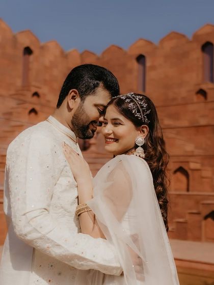 A romantic moment between the couple during their pre-wedding shoot. The bride's makeup is fresh and glowing, perfect for the outdoor setting.