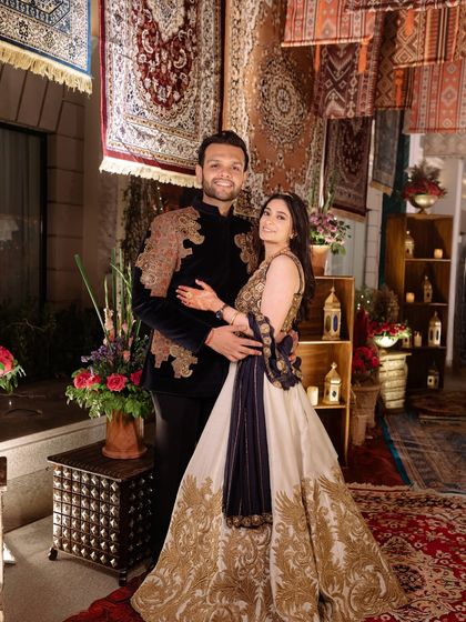The couple poses against the stunning backdrop of hanging rugs and a cozy lounge nook, showcasing how thematic decor creates perfect photo opportunities.