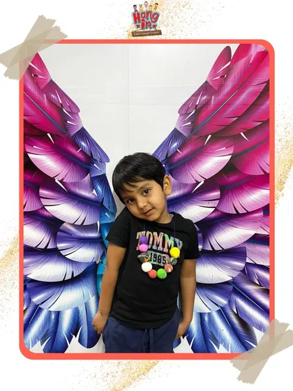 A young boy strikes a cool pose in front of our popular wings mural. It's a favorite photo spot that adds a bit of magic to their day.