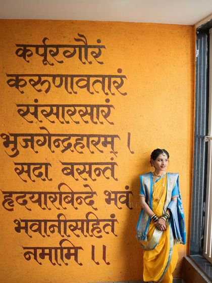 A unique bridal portrait with a Sanskrit shloka painted on the wall, adding a layer of tradition and artistry.