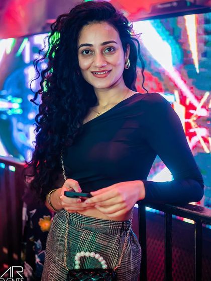 A guest posing against the neon-lit background.