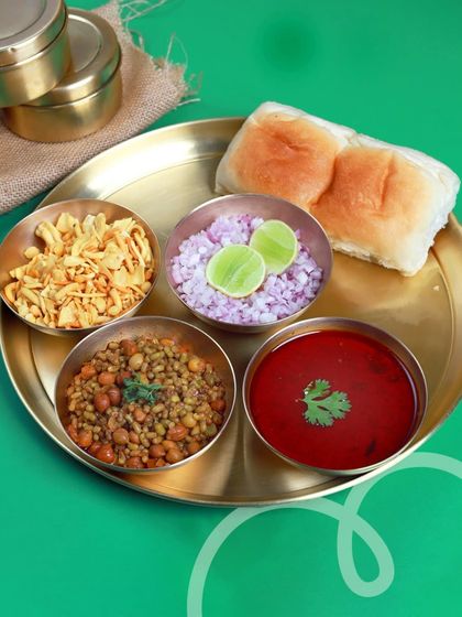 A taste of Mumbai's favorite street food, Misal Pav, served with farsan, chopped onions, and lime. It's a spicy, tangy, and satisfying meal for a change of pace.