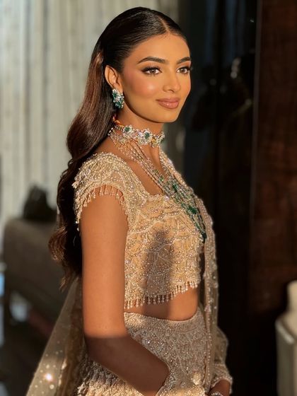 A side profile showing the beautiful waves in her hair and the stunning details of her jewelry.