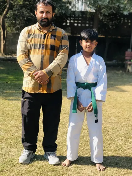 This young student has earned his green belt. Each belt is a symbol of the hard work and dedication he has shown.