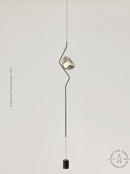 A masterclass in minimalist sophistication, this unique ceiling-to-floor light installation features a slender rod with a single, jewel-like light source. It creates a continuous visual line that adds a futuristic and elegant touch to any modern space.