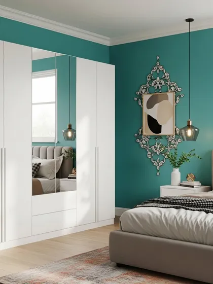This bedroom features a large, white, handleless wardrobe with a full-length mirror panel, making the room feel larger and brighter. The vibrant teal accent wall and decorative pendant light add a touch of personality.