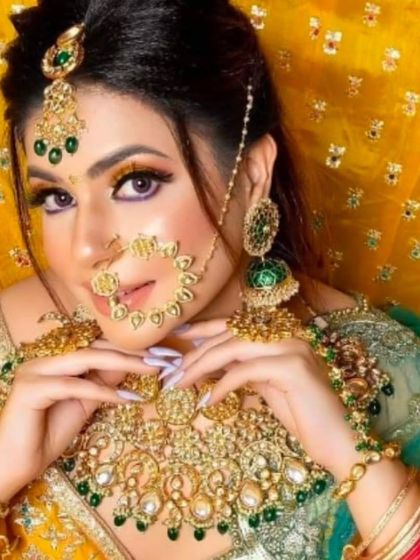 A vibrant Haldi or Mehendi look, with a model wearing a gold and green jewellery set against a bright yellow background.
