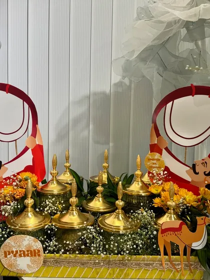 A Rajasthani-themed Rakhi platter with brass-lidded jars. The little camel cutouts and marigold flowers add to the traditional Indian vibe.