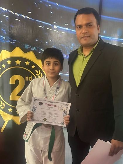 A student proudly posing with his certificate and medal. Each competition helps build resilience and character.