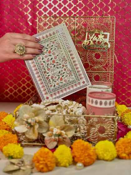 For a gift that speaks of refinement, I designed this Gold Mesh Box hamper. It includes premium dates, coffee, and cookies, all presented in a beautiful floral box with a pearl toran for an auspicious touch.