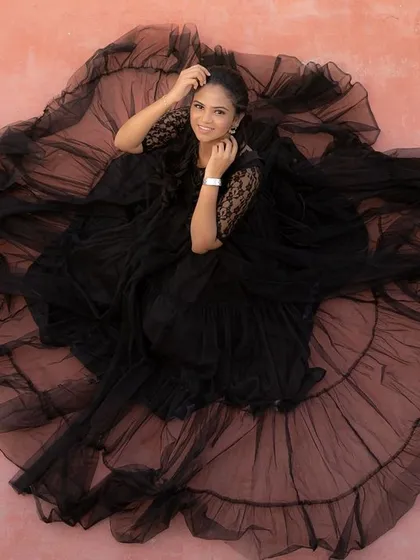 For a truly glamorous and artistic maternity shoot, this black net gown is a showstopper. The voluminous ruffled skirt creates a stunning silhouette from every angle.