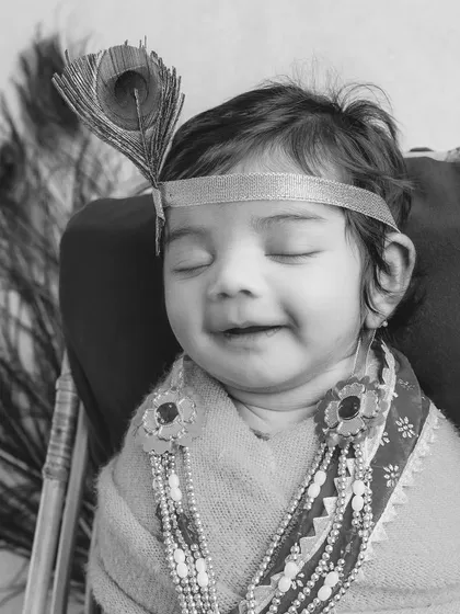 A black and white version of my little Krishna portrait. This style emphasizes the baby's serene expression and the beautiful textures of the costume and peacock feather.