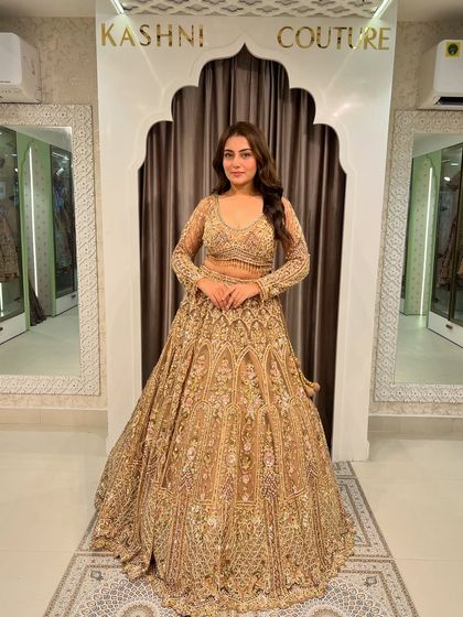 A straight-on shot of the glittery golden lehenga, showing off its full-sleeved blouse and the incredible sparkle of the fabric.
