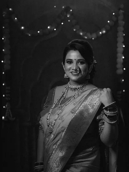 A timeless black and white portrait capturing the festive glow of Diwali, with twinkling lights in the background.