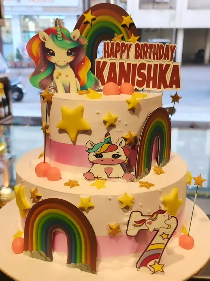A magical two-tier unicorn cake that's perfect for a fantasy-themed birthday. Decorated with rainbows, stars, and adorable unicorn characters, this cake is sure to enchant the birthday girl.