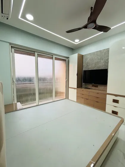 This view from the bed shows the TV unit and the large window, demonstrating how I consider natural light and views when designing a room's layout.