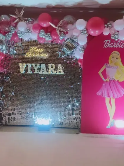 A glamorous Barbie-themed party for Viyara's 5th birthday. I used a pink sequin wall, Barbie cutouts, a light-up name and number, and a pink and silver balloon arch to create a fun and stylish celebration.