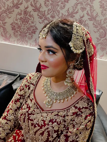 A side profile of the bride, highlighting the flawless makeup and the intricate details of her traditional jewelry.