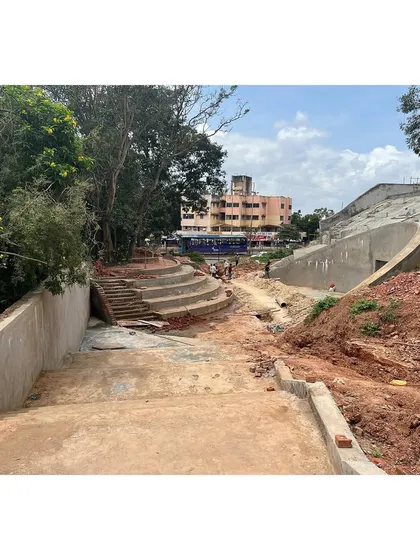 A construction photo of the sports center's landscaped entrance, showing the formation of the concrete steps and amphitheater-style seating areas.