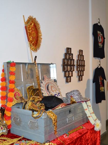 The Consul General looking at the collection of costumes and props.