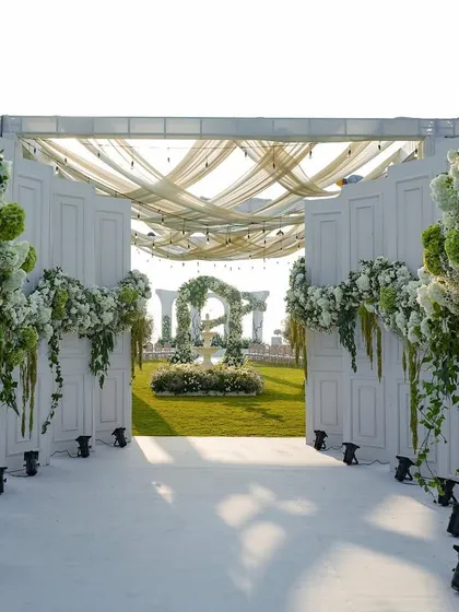 We orchestrate timeless celebrations, like this pristine white wedding in Goa. The grand entrance opens to a serene garden vista, framed by cascading white florals and elegant drapery, promising a day of classic romance and sophisticated beauty.