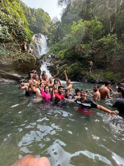 A group of trekkers taking a refreshing dip in a waterfall pool during our Gokarna trip.