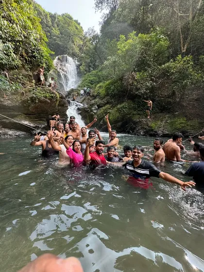 A fun group photo of everyone enjoying a dip in a waterfall pool during our Gokarna long weekend trip.