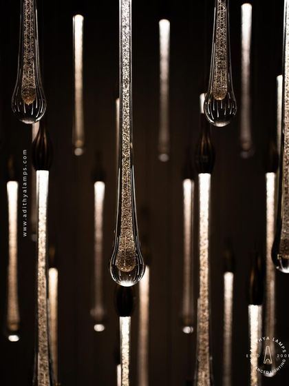 A stunning cluster of crystal teardrop pendants. Each pendant contains bubble-like inclusions that catch the light, creating a sparkling, rain-like effect. This is an elegant choice for double-height foyers or modern staircases.