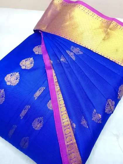 A royal blue silk saree with a simple gold border, pleated and box-folded.