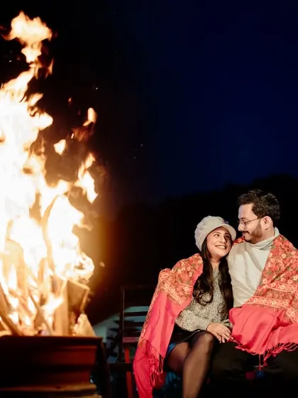 Cozying up by a bonfire under the night sky. I focus on creating a warm, intimate atmosphere for night shoots, using the firelight to capture the genuine connection and comfort you share.
