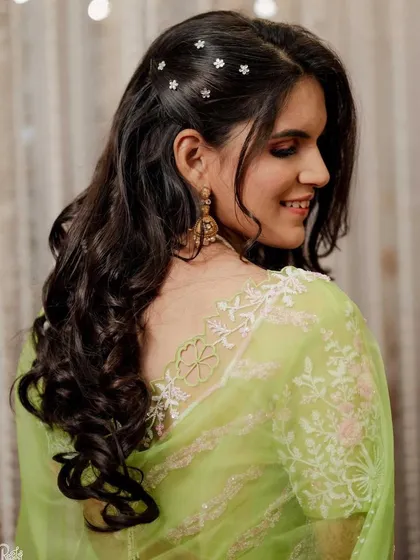 A back view of this engagement bride's look, showing off her beautiful wavy hair with delicate star accessories.