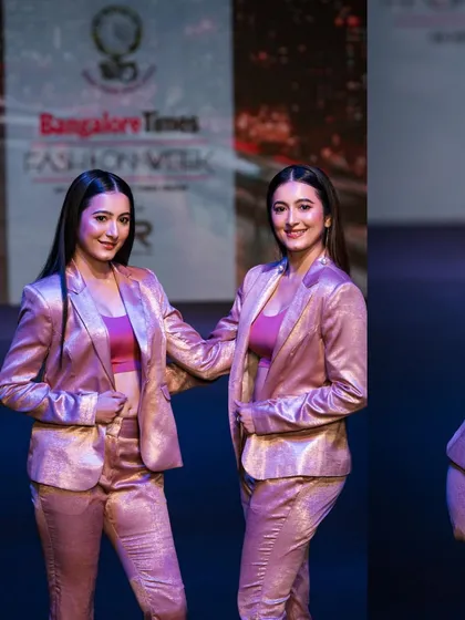 A shot of the Shetty twins walking the ramp in matching metallic suits for a designer at Bangalore Times Fashion Week. Capturing multiple models in a single frame requires precise timing and composition.