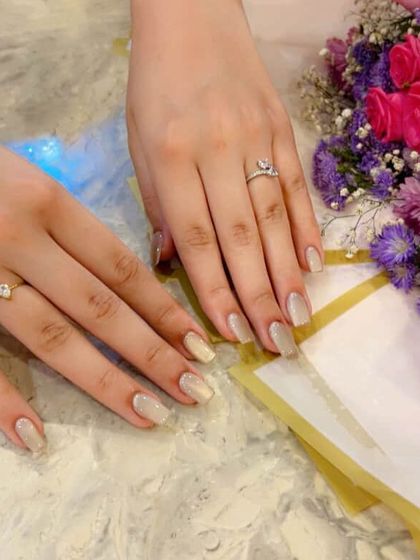 The nude cat eye nails looking elegant against a bouquet of flowers.