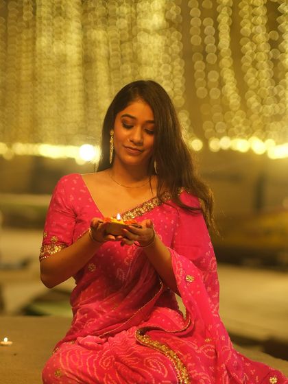 A quiet moment of prayer, holding a diya on the steps of the ghat. This image captures the personal and spiritual side of the Dev Deepawali celebration.
