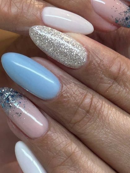 A beautiful and intricate design featuring a mix of solid pastel blue, sparkling silver glitter, and a glitter ombré effect on a nude base.