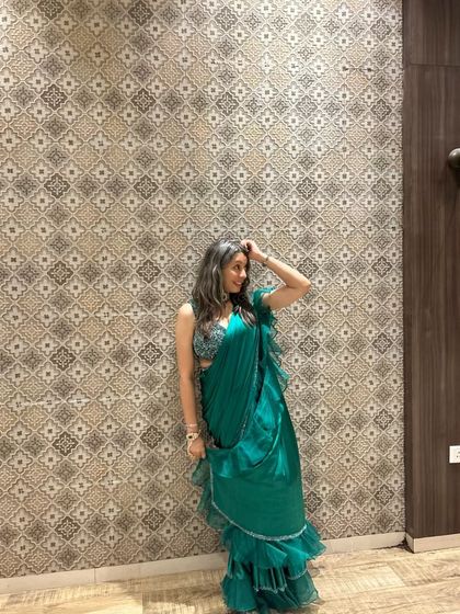 Shining bright in our green pre-draped ruffle saree. It's a fun and fashionable choice for any party.