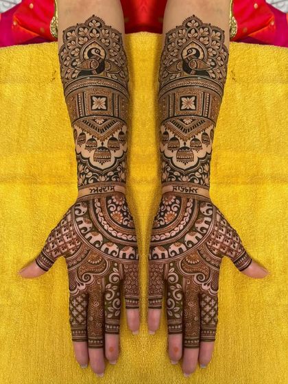 A personalized bridal design with the couple's names, surrounded by peacocks and other traditional motifs.