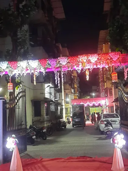 An illuminated floral archway creates a welcoming entrance for guests at a society building event. This setup is perfect for transforming a regular entryway into a special passage for a wedding or reception.